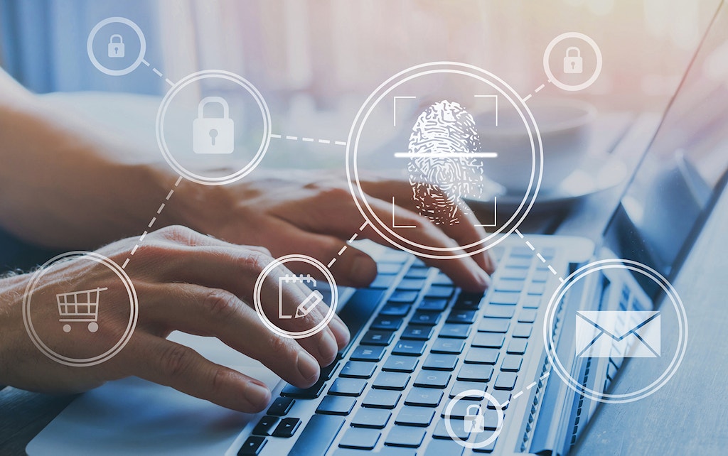Hands typing on a laptop keyboard with overlay icons of a fingerprint, lock, shopping cart, and email, representing online security and authentication.