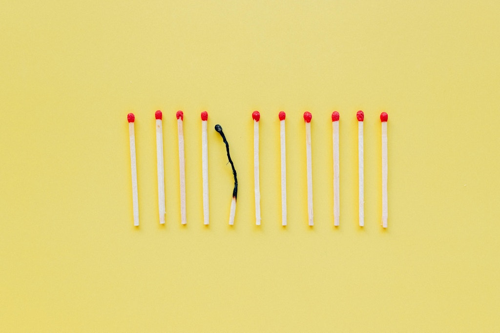 A burnt out match among other new ones